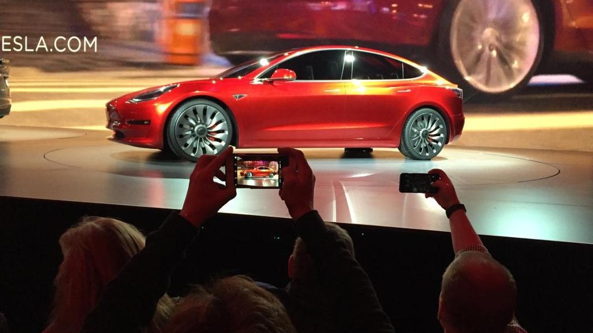 Tesla Motors unveils the new lower-priced Model 3 sedan at the Tesla Motors design studio in Hawthorne, Calif., Thursday, March 31, 2016. It doesn't go on sale until late 2017, but in the first 24 hours that order banks were open, Tesla said it had more than 115,000 reservations. Long lines at Tesla stores, reminiscent of the crowds at Apple stores for early models of the iPhone, were reported from Hong Kong to Austin, Texas, to Washington, D.C. Buyers put down a $1,000 deposit to reserve the car.