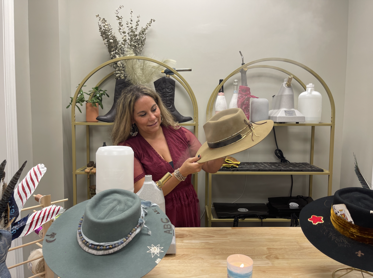Lauren Dembeck, the founder of Brims on the Bluff, steams a hat at the store’s grand opening Tuesday. 