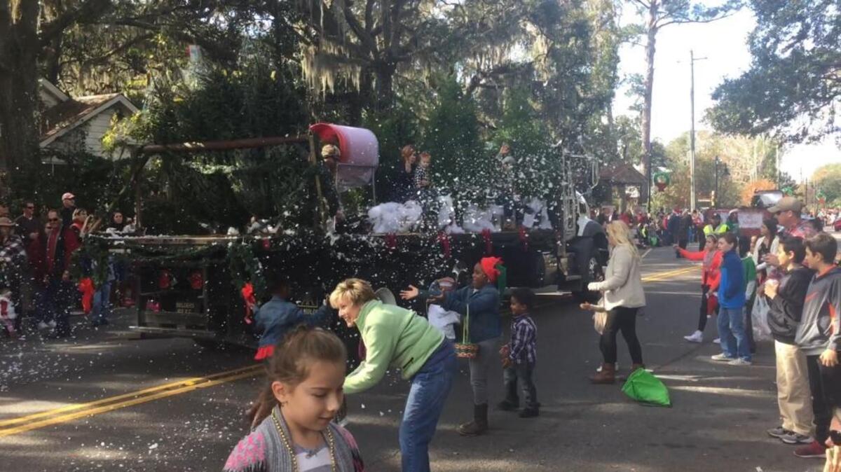 Kids gather faux snow as a float drives by on May River Road in Old Town during the annual Bluffton Christmas Parade Saturday morning.