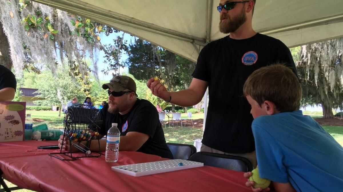Former Army Specialists Paul Hurtt, left, and Austin Horne, both of Beaufort, call out Bingo during the Technical College of the Lowcountry’s Day of Service for veterans and their families on Saturday while Brady Copeland, 9, looks on. Hurtt serves as vice president of the Student Veterans of America, TCL chapter, and Horne serves as president.