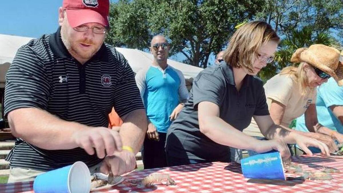 People participate in a shrimp heading contest at a past Beaufort Shrimp Festival.