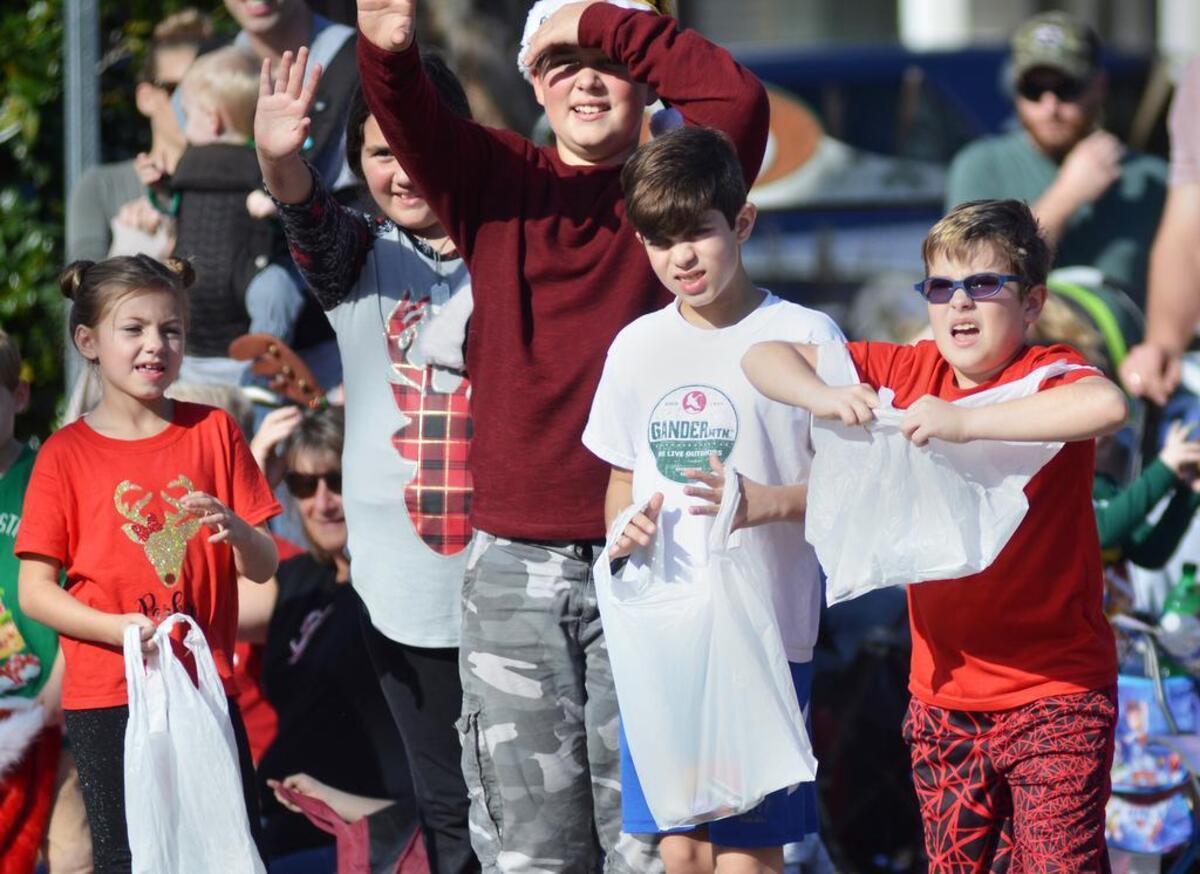 Kids clamor for candy along May River Road as the Bluffton Christmas Parade passes them by.