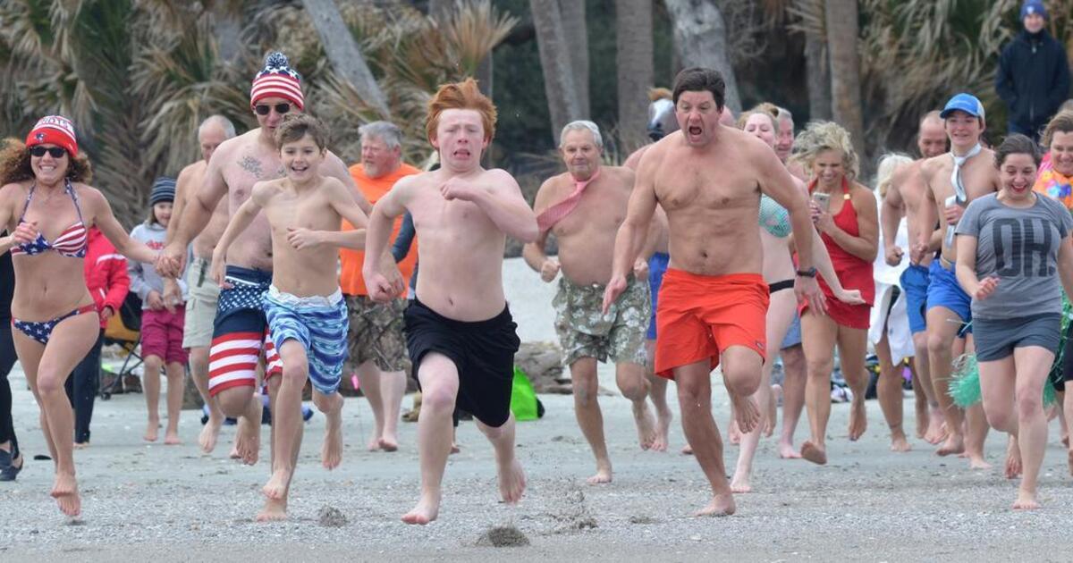 Participants in the annual New Year’s Day Pelican Plunge at Hunting Island charge toward the water in 2018.