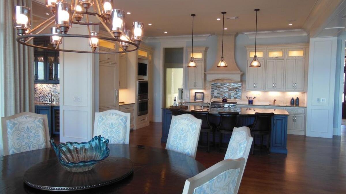 The open concept floorpan of my clients’ home in Colleton River allows the kitchen and dining room to easily flow together but avoids the eat-in-kitchen feel. A working pantry is cleverly hidden behind a cabinet door to the right of the ovens, helping hide clutter. An eclectic mix of furnishings keeps the dining area from feeling too formal.