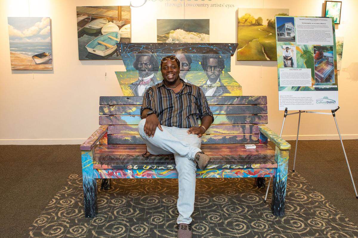 Omar Patterson sits on the bench he painted, which is located at the corner of Bladen and Duke Streets. The theme of his bench is Lowcountry Dreaming.