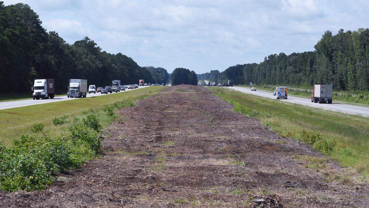 Only disturbed earth and wood chips remain between the travel lanes of I-95 on Aug. 20, 2018 after the formerly tree-filled stretch of median had been clear cut in this view looking south near mile marker 27 in Jasper County.