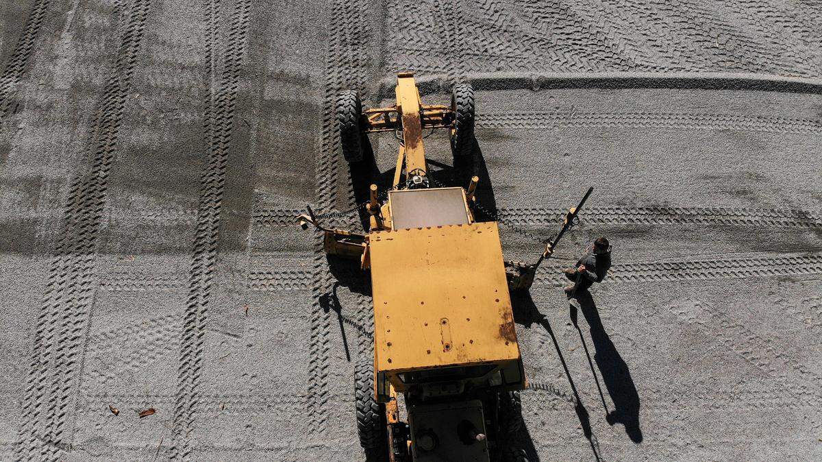 A heavy duty motor grader pushes a gavel mixture into gravel grids for a porous parking solution at C.C. Haigh Jr. Boat Landing as seen on Dec. 18, 2023, on Pinckney Island. Beaufort County is improving parking at the landing for the public ferry to Daufuskie Island until the county acquires land for the long term embarkation site at Cross Island Boat Landing on Hilton Head Island.
