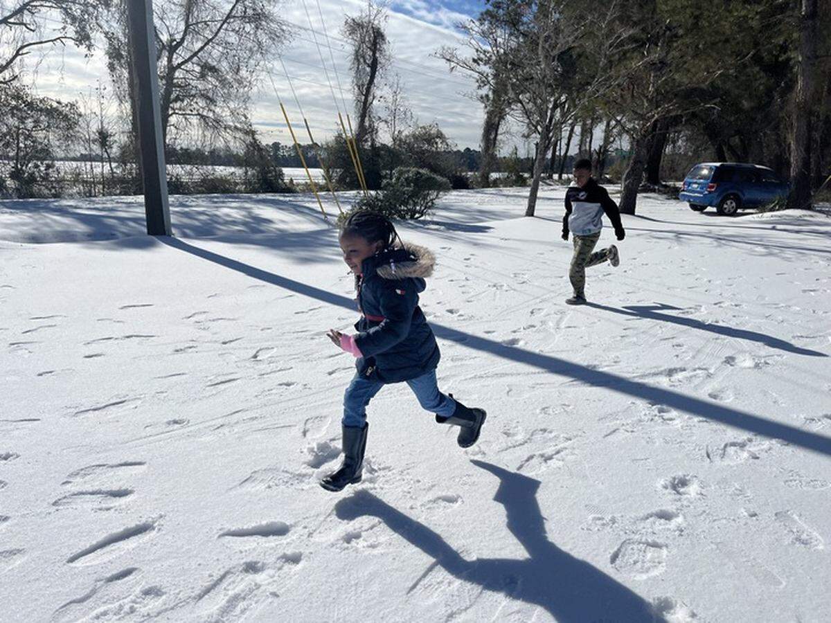 Zariah Evans, 4, and Josiah Mikell, 10, play in newly fallen snow on Lands End Road and Sam Doyle Road on St. Helena Island.