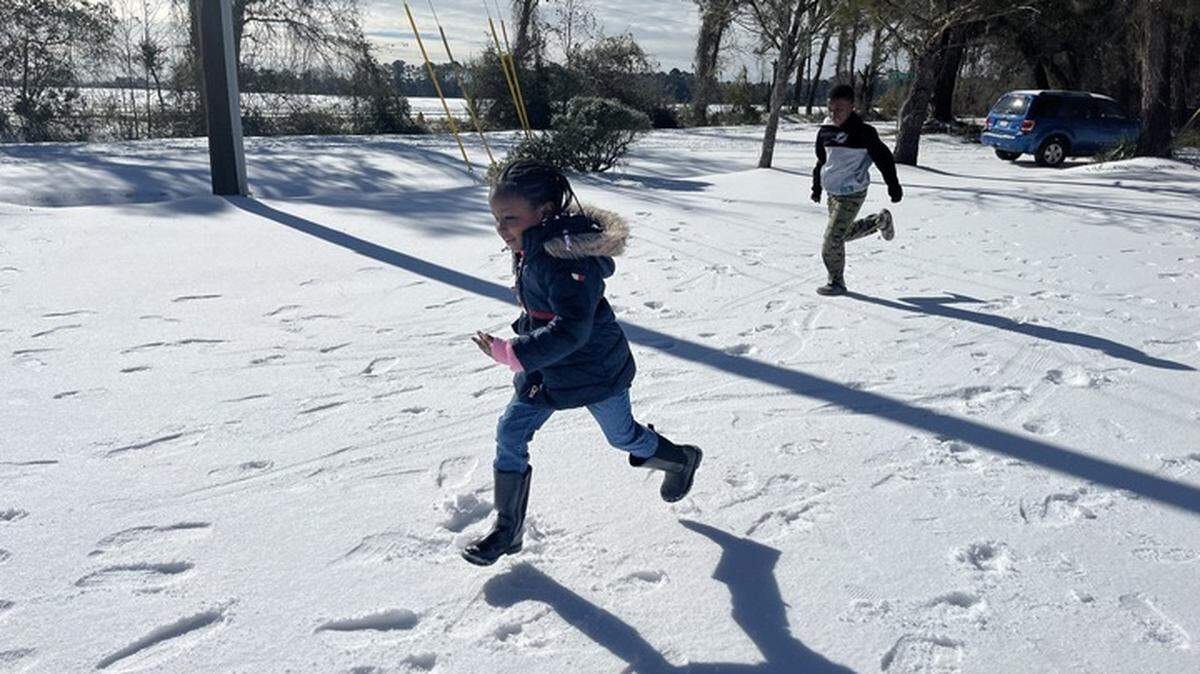 Zariah Evans, 4, and Josiah Mikell, 10, play in newly fallen snow on Lands End Road and Sam Doyle Road on St. Helena Island.