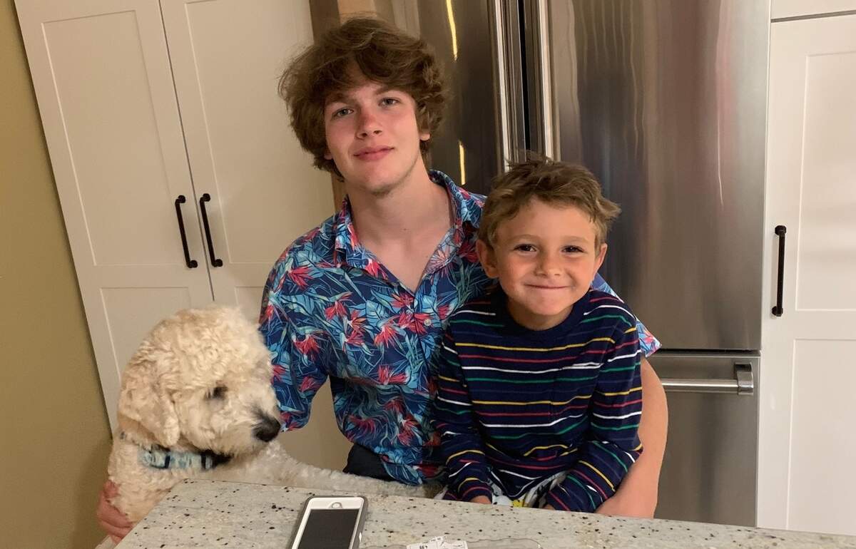 Laer Hohmann of Hilton Head is photographed with one of his younger brothers and their golden doodle Zeus.