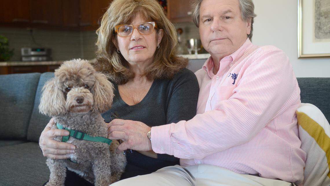 Alexis and Bill Buryk sit for a portrait in their home on Monday afternoon on Hilton Head Island with their dog Coco. The Buryk's fraternal twin daughters, Allie and Katie, have been diagnosed with a rare disease, late onset Tay-Sachs.