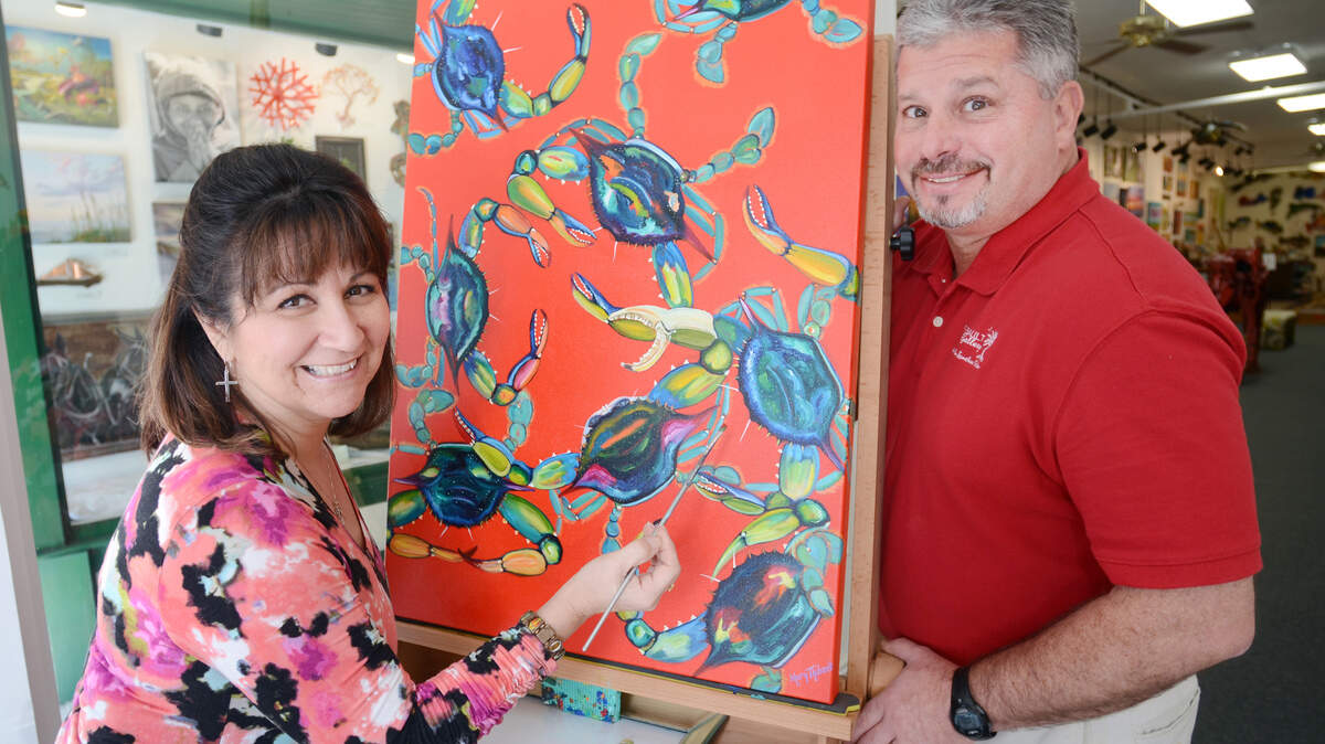 Mary and Eric Thibault, owners of Beaufort's Thibault Gallery, are photographed with one of Mary's paintings on Thursday.
