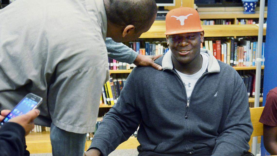 Carl Williams congratulates his grandson, senior Poona Ford, at a signing day ceremony at Hilton Head Island High School on Wednesday night. Ford announced earlier in the day that he was going to play football with the Longhorns of the University of Texas. "He's done well," said Williams of his grandson, "no matter what happens with his football career, he's going to have a good life and a good college education."