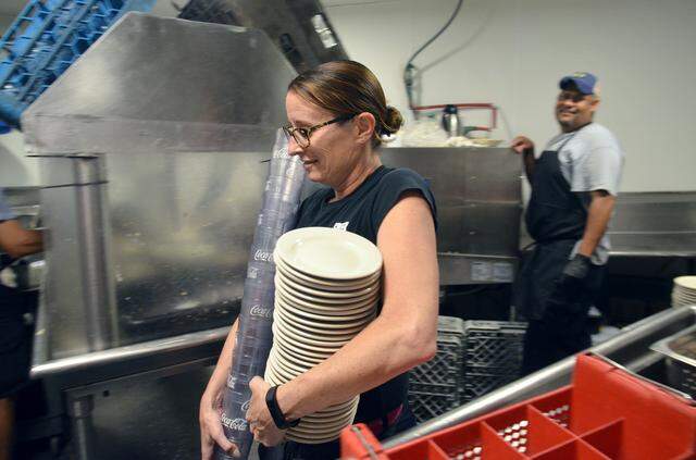 Kelly Homan carries glasses and plates to her waiters station at the beginning of her shift at Hilton Head Island's Skull Creek Boathouse restaurant on Saturday, April 28, 2018. To make ends meet, Homan, who is a guidance counselor at Bluffton High School, works at the restaurant on weekends during the school year and during summer break.