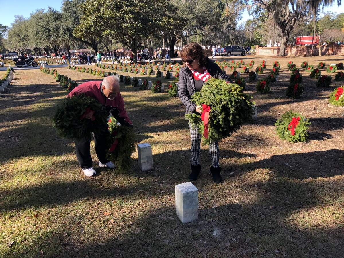Joe Fulgieri and Lynn Crouse of Beaufort place wreaths at headstones at Beaufort National Cemetery on Saturday.