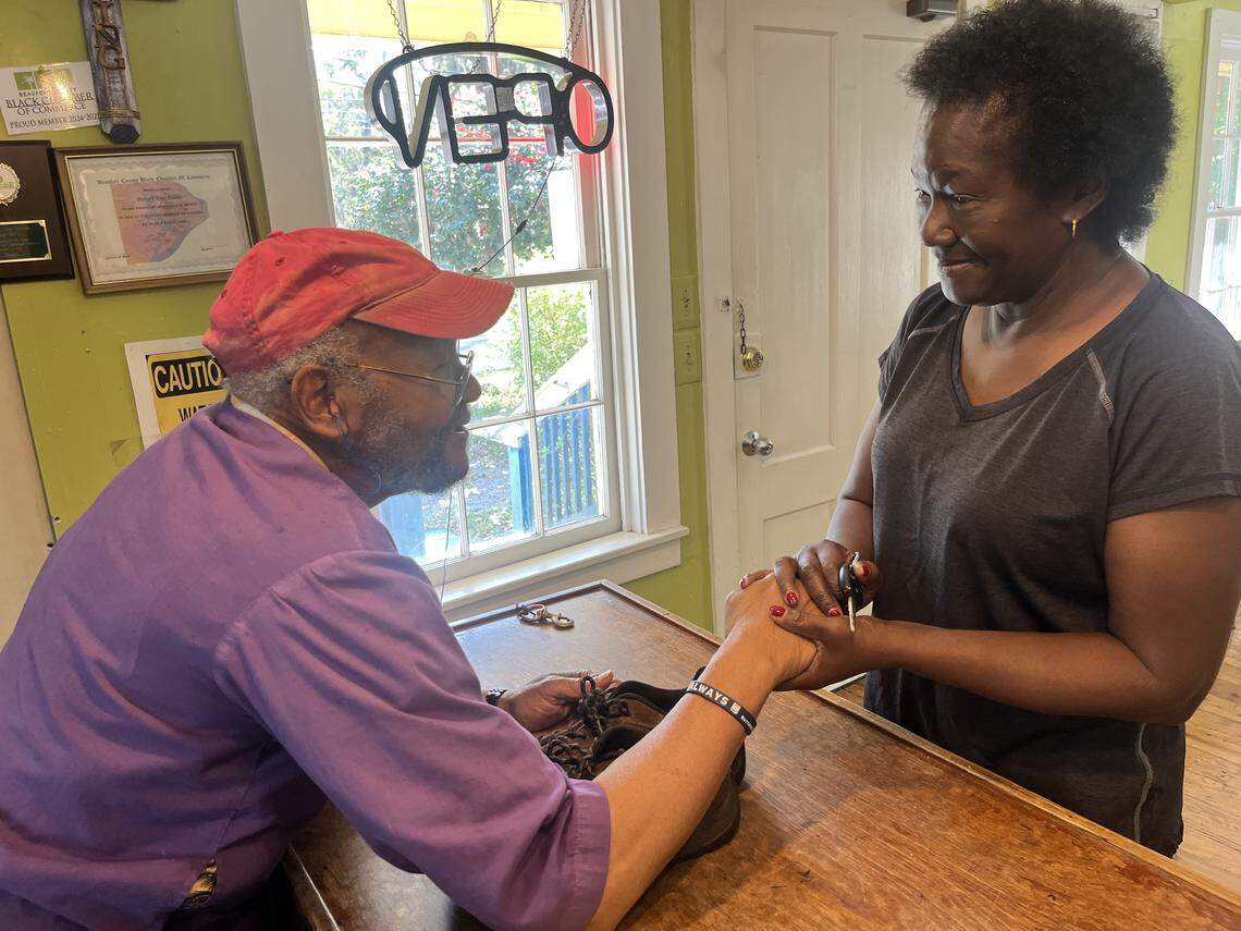 Stephen Mobley greets Mary Tompkins at Mobely’s shoe repair store on day in March.