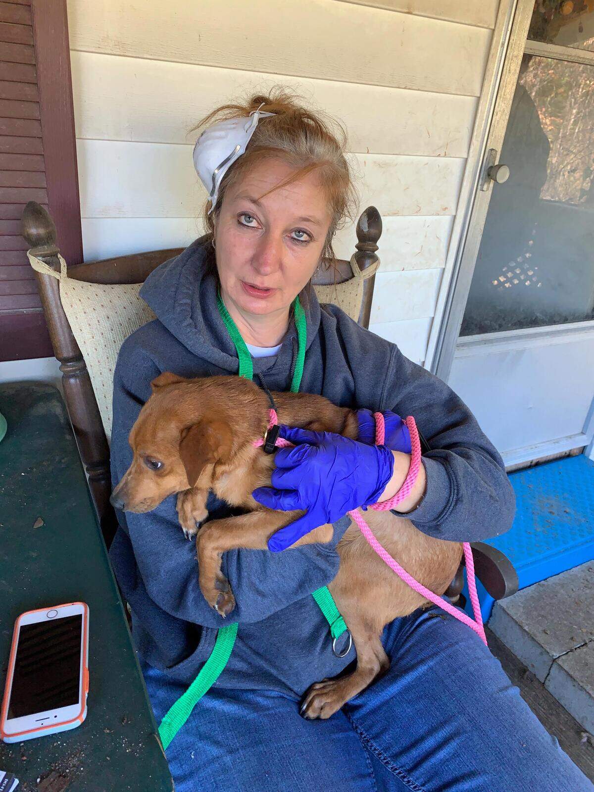 Manuela Schafer, one of the three people that conducted the six-hour-long rescue to save 24 dogs from a single home near Columbia, S.C., takes a break outside the home with one of the rescued dogs.
