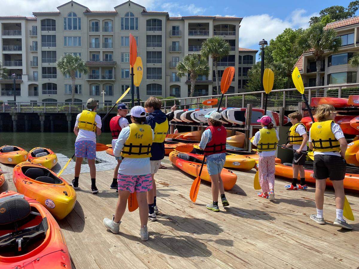 Students from Hilton Head Christian Academy gearing up with life jackets and paddles before making a kayaking excursion on the Broad Creek to learn about the environment Monday, May 9, 2022 on Hilton Head Island.