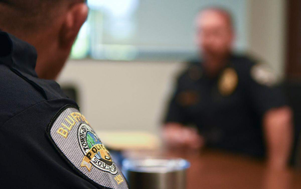 A Bluffton Police Department patch worn by Capt. Joe Babkiewicz, foreground, spokesman for the department, at police headquarters as Chief Chris Chapmond, background, talks about the new hiring practices the department has implemented.