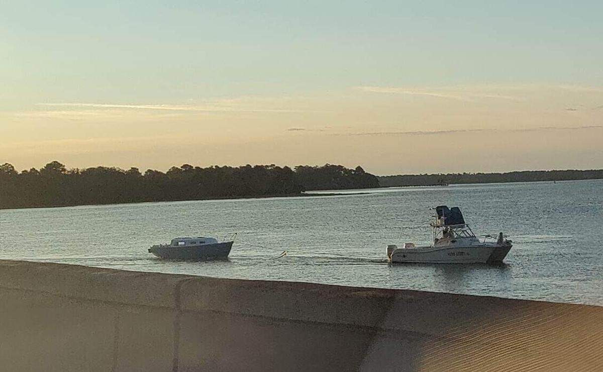 A photo of “little blue boat’s” removal taken at approximately 7:45 on Saturday morning. Two men sat inside the boat towing away the popular blue and white vessel.