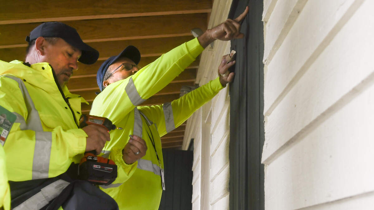 Town of Bluffton Works employees Rich Tynon, left and Brian Ranger work together on Wednesday afternoon to secure the shutters, some of which are original to the structure, at the historic Cyrus Garvin House at Bluffton’s Oyster Factory Park. The workers were preparing for the worst from Hurricane Dorian which was off shore producing rain and storm surge for the Lowcountry.