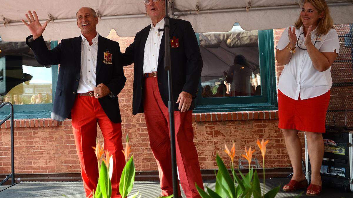 Bill Damude, left, the 2015 commodore, waves to the crowd after being presented with his commodore jacket by Colden Battey, center, the 1966 commodore, and 2014 Commodore Brandy Gray on Saturday night at the Change of Watch Ceremony at the Old Bay Marketplace Loft and Rooftop Deck in Beaufort.