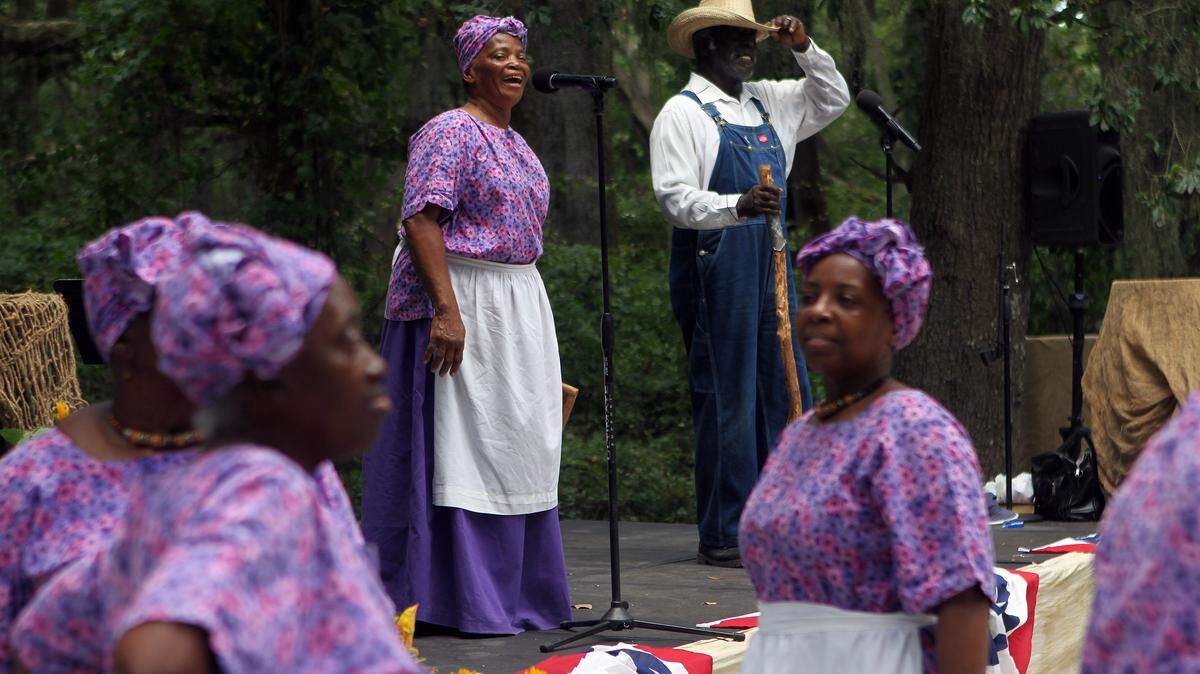 Joann Ross and Jack Evans sing a song on stage while the rest of the Geechee Gullah Ring Shouters dance during the Juneteenth Celebration hosted by the Mitchelville Preservation Project on Saturday afternoon at the Fish Haul Park on Hilton Head Island.