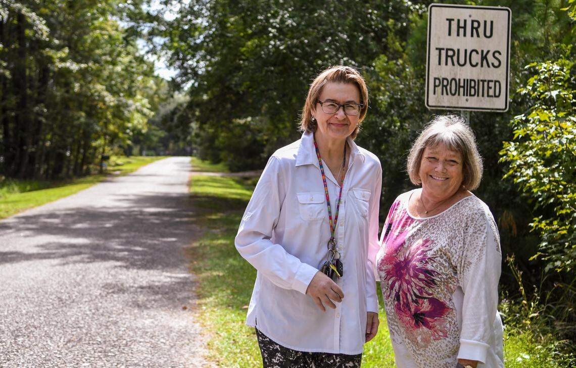 Neighbors Jackie Reynolds, left, and Shannon Smith stand for a portrait in their Bass Lake neighborhood on Sept. 24, 2020 in Ridgeland, S.C. Reynolds fought to have signs placed to keep logging and box trucks from using the neighborhood as a cut through. On Sept. 20, 2020, environmental groups sent a letter with intent to sue to the owner of Jasper Pellets, a wood mill, who they say has been converting wood chips into pellets without having federal and state permits.