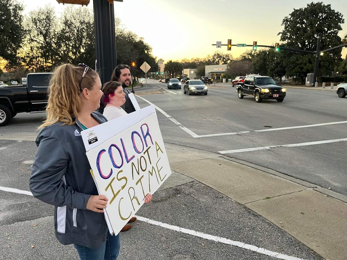 From left, Courtney Cadien and Samantha and Adam Stricker rally hold signs in protest against Trump administration policies Monday at Ribaut Road and Boundary Street in Beaufort.