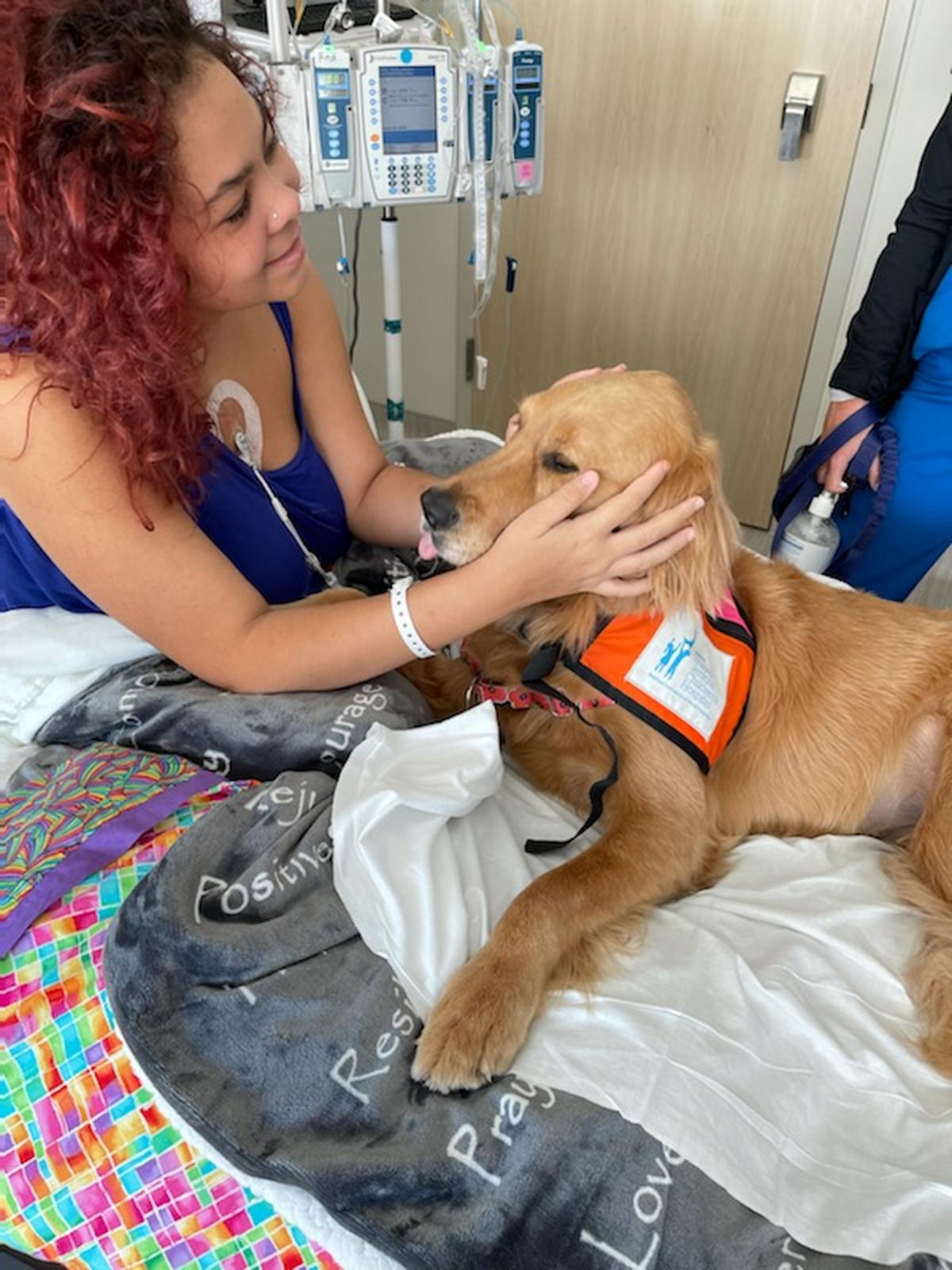 Lexi Busby, 16, pets a dog in her hospital room at the Medical University of South Carolina in Charleston where she was diagnosed with aplastic anemia.