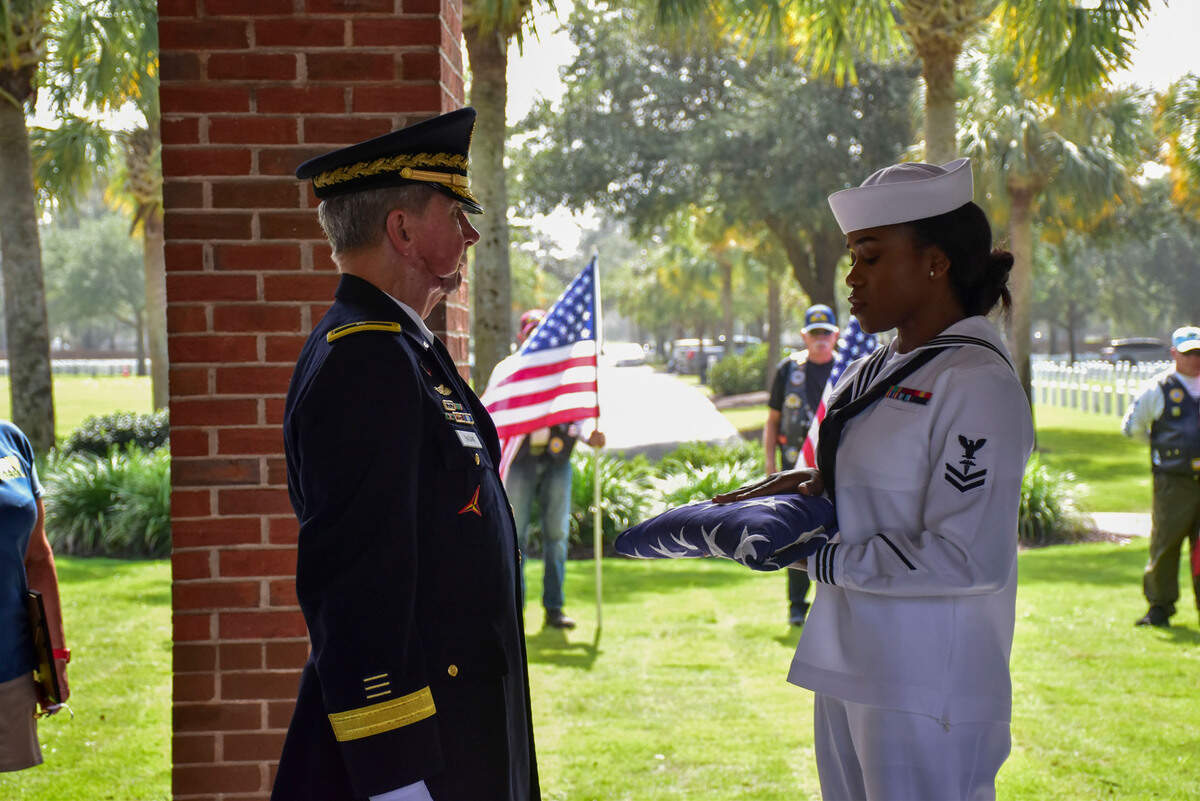 Brigadier General (Ret) Jack Hagan accepts a flag from Corpman 2nd Class Santana Parchment during the internment for two Unclaimed Veterans at Beaufort National Cemetery. The veterans, Donald Brown and David Dickson served in the Navy during the Vietnam War and they were both from the Lowcountry area.