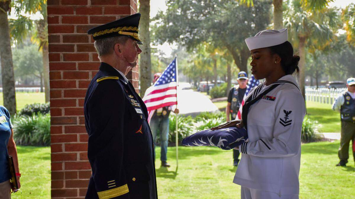 Brigadier General (Ret) Jack Hagan accepts a flag from Corpman 2nd Class Santana Parchment during the internment for two Unclaimed Veterans at Beaufort National Cemetery. The veterans, Donald Brown and David Dickson served in the Navy during the Vietnam War and they were both from the Lowcountry area.