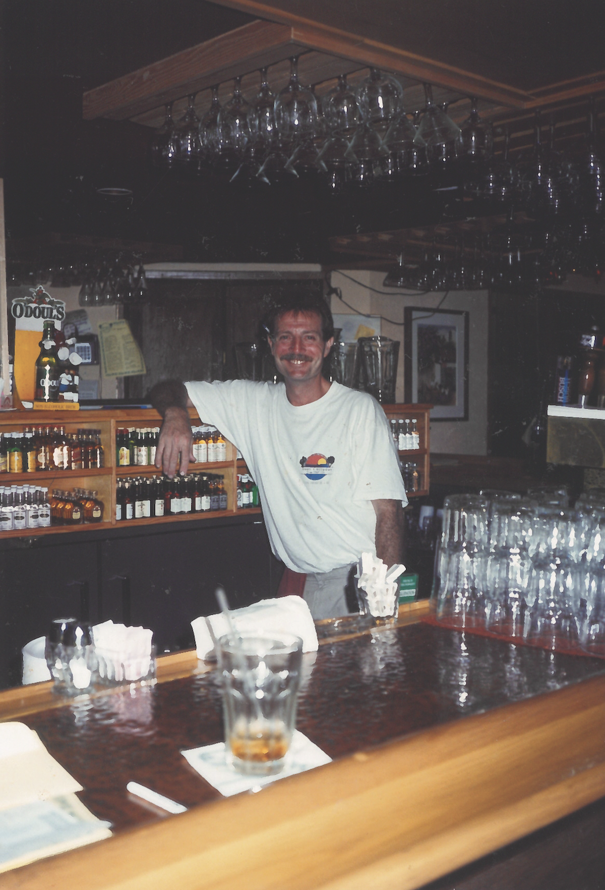 Tommy Maus stands behind the bar counter in the ’90s.