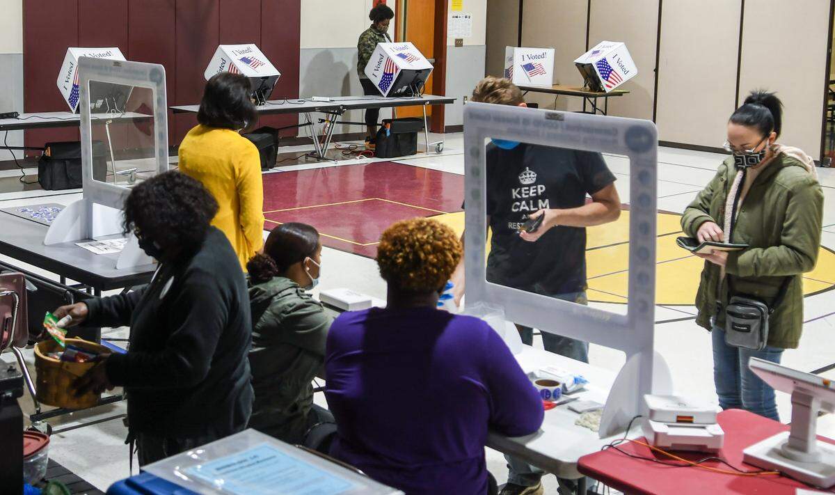 Poll workers help voters in the general election on Tuesday, Nov. 3, 2020, at Shanklin Elementary School in Seabrook.