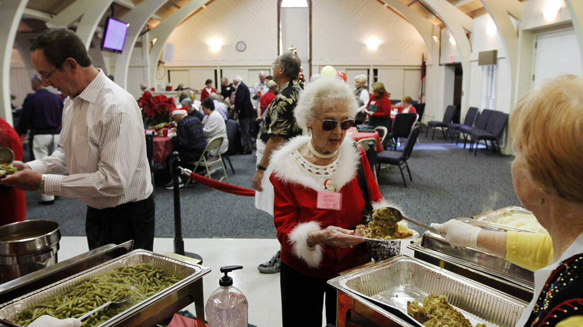 Volunteer Janet Donnelly, of Sun City Hilton Head, right, serves a scoop of stuffing to Betty Nemec on Wednesday at the Community Christmas Day Dinner hosted by First Presbyterian Church.