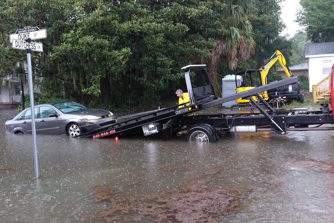 A tow truck operator pulls a car from a flooded Duke Street in downtown Beaufort on Thursday, July 19, 2018.