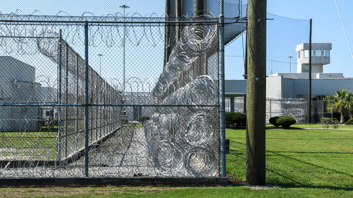 Coiled rolls of barbed wire sit between double fences as the guard tour looms in the background near the front entrance to the S.C. Department of Corrections Ridgeland Correctional Institution as seen on Aug. 6, 2020, located at Exit 22 on Interstate 95 in Ridgeland, S.C.