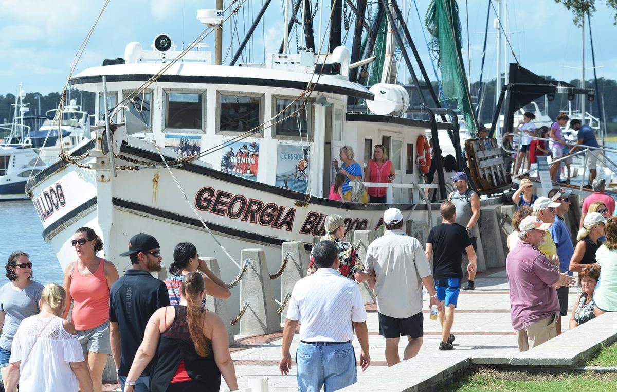 Festival goers walk past the shrimp boat Georgia Bulldog which was offering free tours during the Beaufort Shrimp Festival in 2017 at Henry C. Chambers Waterfront Park.