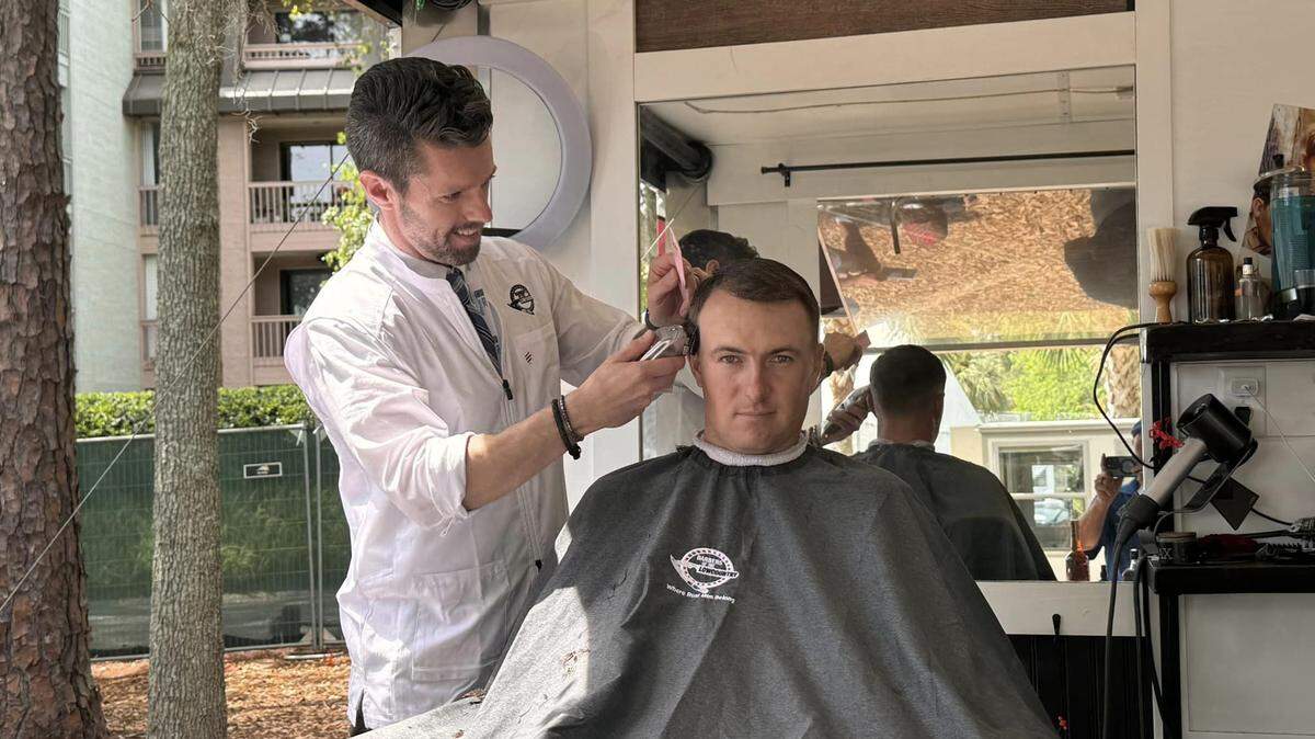 Barber Paddy Myers of Barbers of the Lowcountry gives PGA Tour star Jordan Spieth a haircut on April 17, 2024 in a mobile shop at the RBC Heritage golf tournament on Hilton Head Island, S.C.