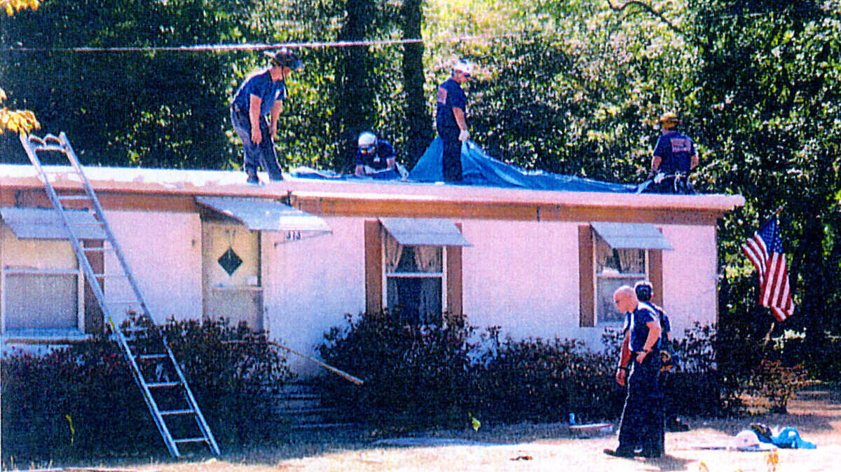 In this photo from the report produced by the government, emergency responders place tarps over the home of Margaret Tiedemann's Pine Grove Home and look for debris from the April 21, 2007 Beaufort Air Show plane crash.