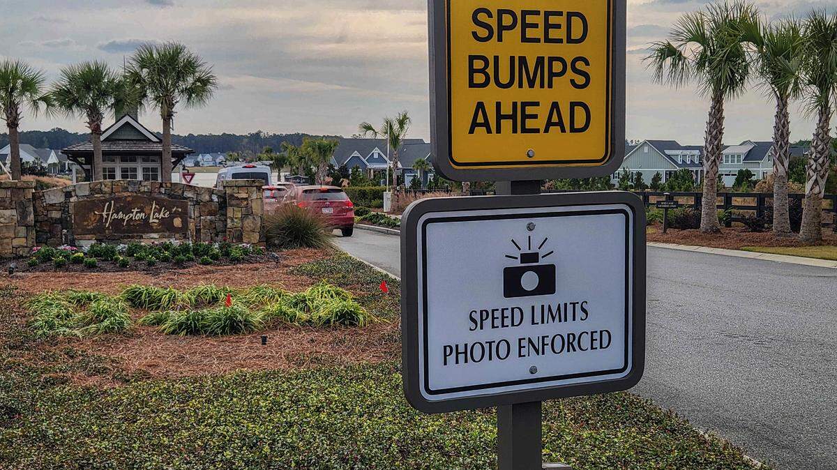 Signs before the gate to Hampton Lake warns drivers of speed bumps as well as speed limits enforced with cameras as photographed on Nov. 21, 2025, in Bluffton. While the roads within gated communities are private, South Carolina is one of a few states that bans the use of speed-enforced cameras on public roads.