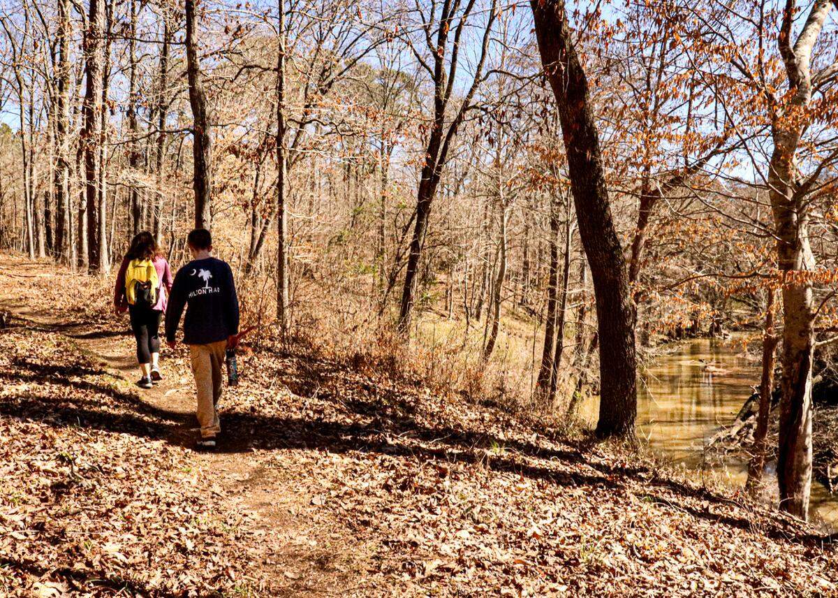 Hikers enjoy the sunny winter afternoon along the Turkey Creek Trail near Augusta. The trail is moderately challenging as it ascends and descends the bluffs along the creek, which flows over rocky falls below.&nbsp;