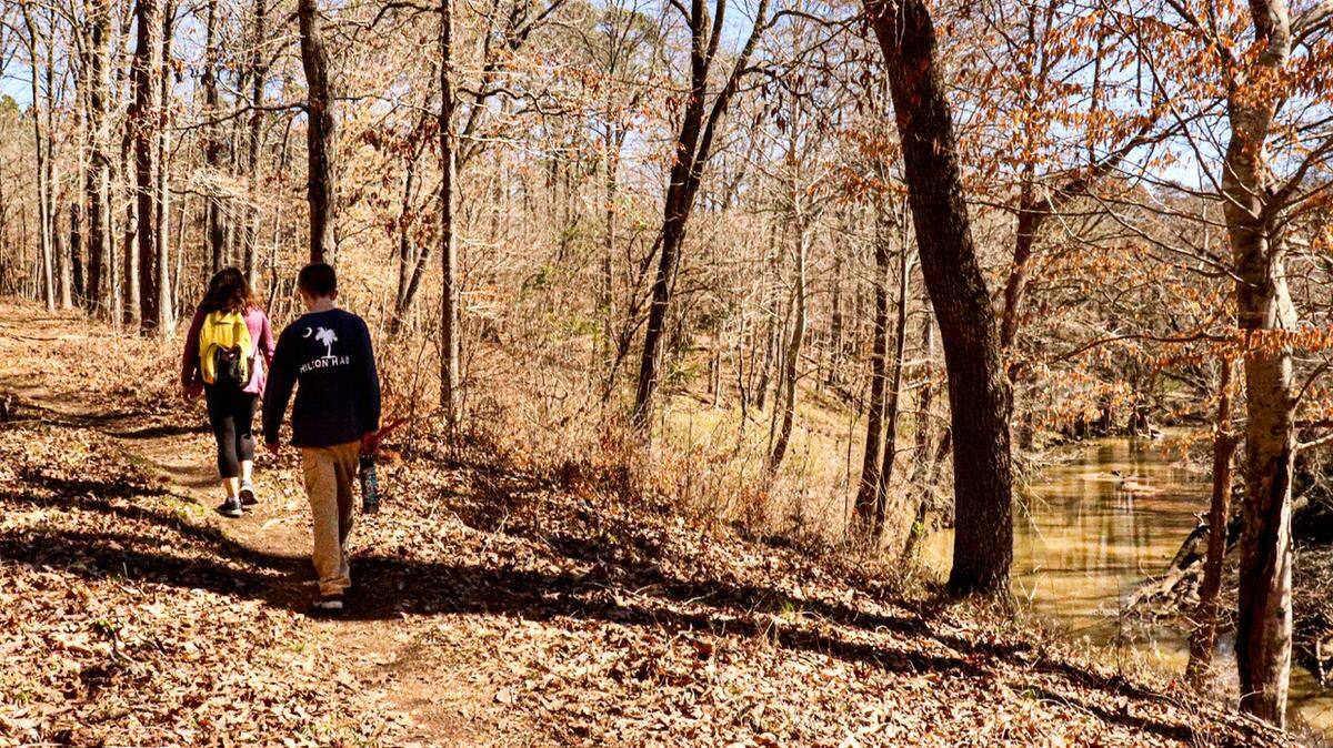 Hikers enjoy the sunny winter afternoon along the Turkey Creek Trail near Augusta. The trail is moderately challenging as it ascends and descends the bluffs along the creek, which flows over rocky falls below. 