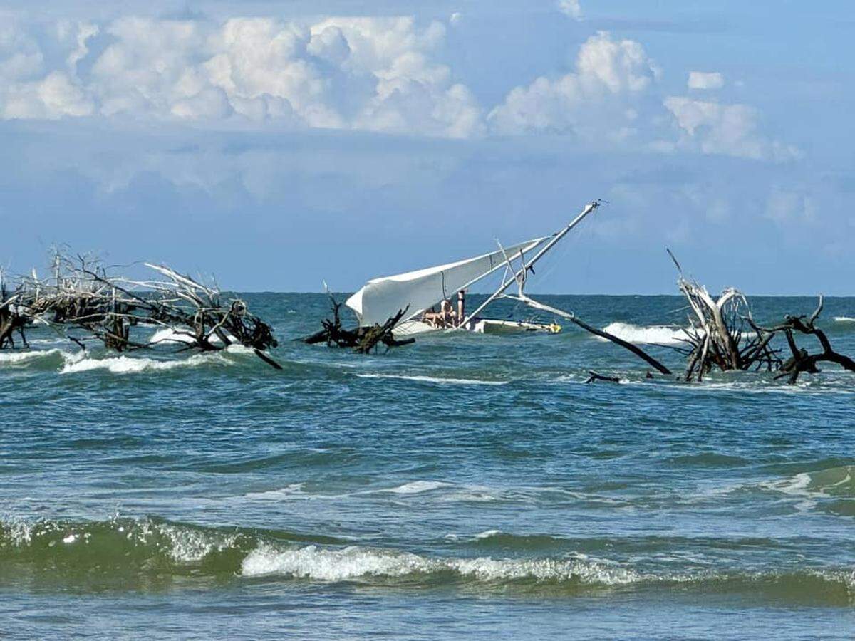 People were playing on a stranded sailboat at Hunting Island State Park on Saturday.