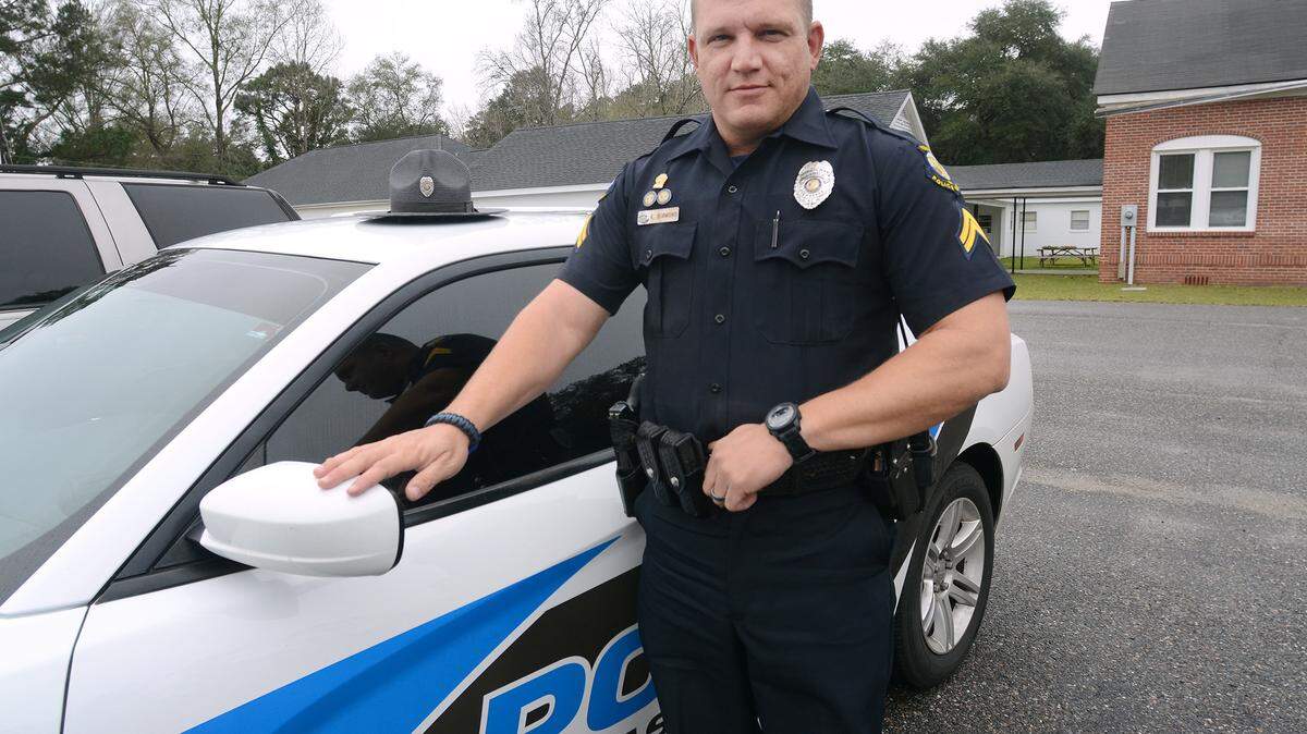 Yemassee police officer Kenneth Simmons is photographed next to his cruiser on Friday.