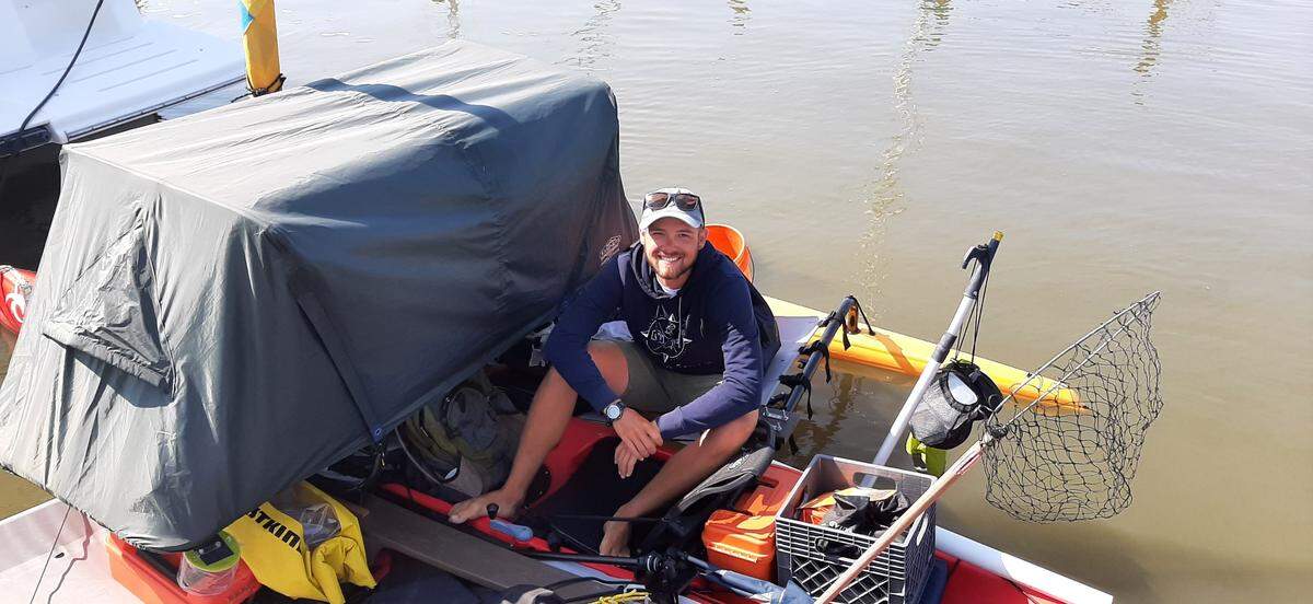 Will Freund on his 16-foot kayak, complete with a sail, tent and foot pedals, at the Beaufort marina Friday.