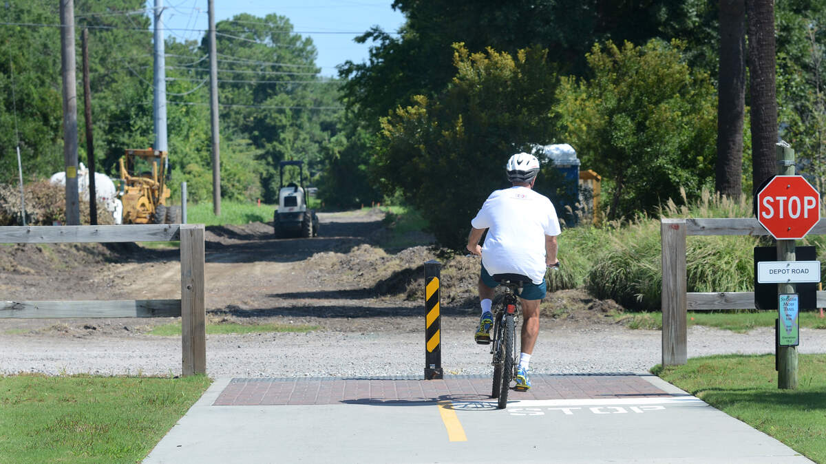 A biker reaches the Depot Road terminus of the Spanish Moss Trail on Friday. Work has begun, visible in background, on an extension of the trail that will extend from Depot Road to Broad River Boulevard.
