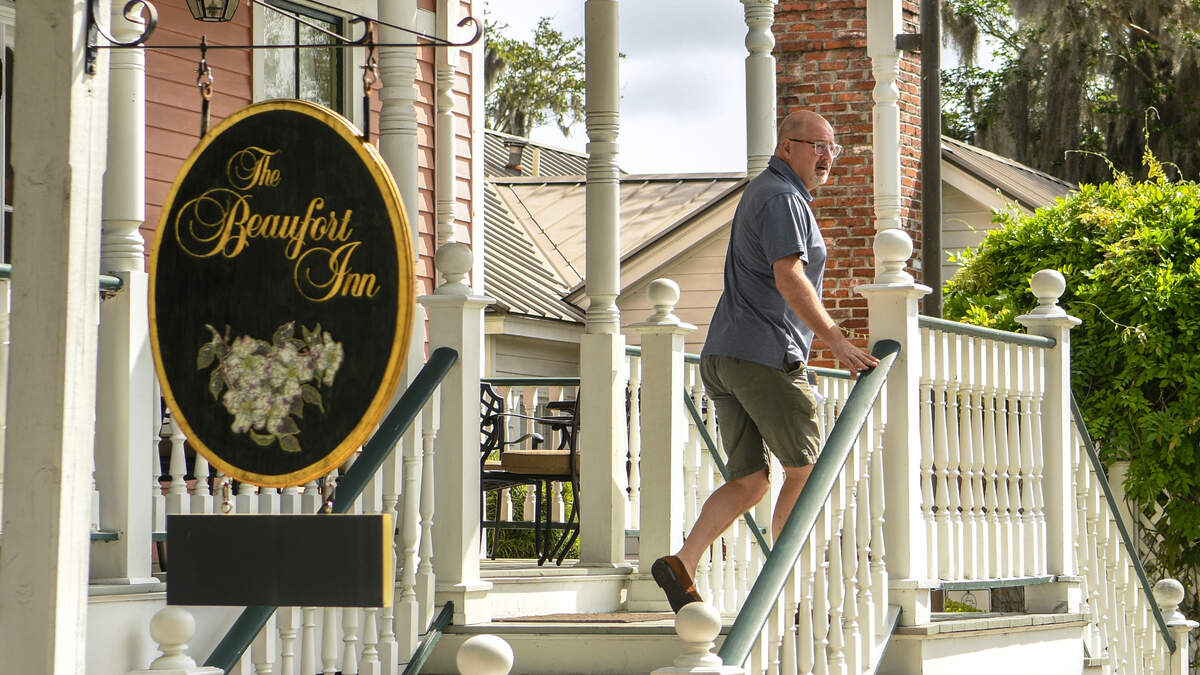 Graham Trask ascends the stairs at The Beaufort Inn on April 7, 2023, to illustrate where a hotel – on the corner of Port Republic and Scott streets – is planned to be built by Dick Stewart of 303 Associates in Beaufort’s historic district. Trask and Historic Beaufort Foundation challenged the City of Beaufort’s approval to build the hotel and a parking garage that a state court of appeals has recently upheld.