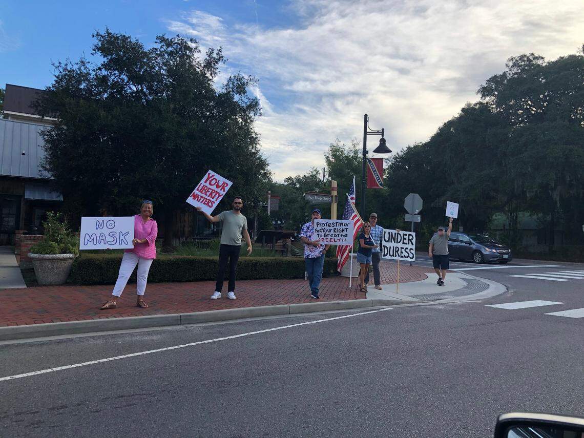 A small group of protesters hold signs and wave at passing cars Tuesday, Sept. 8 at the four-way stop at May River Road and Boundary Street in Old Town Bluffton. The group was protesting Bluffton’s mask ordinance.