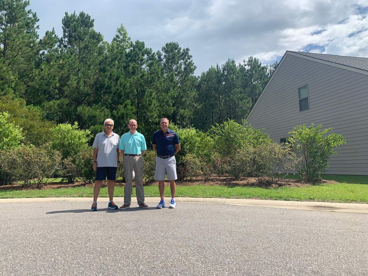Residents Dave Disney, Rich Gawrysiak, and Larry Mattingly stand in front of the plot that Sun City plans to place a public restroom on.